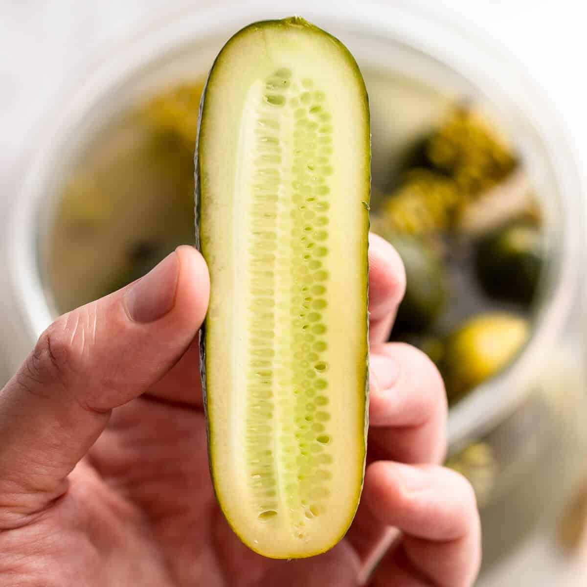 Two fresh green mini cucumbers and sliced half with three slices